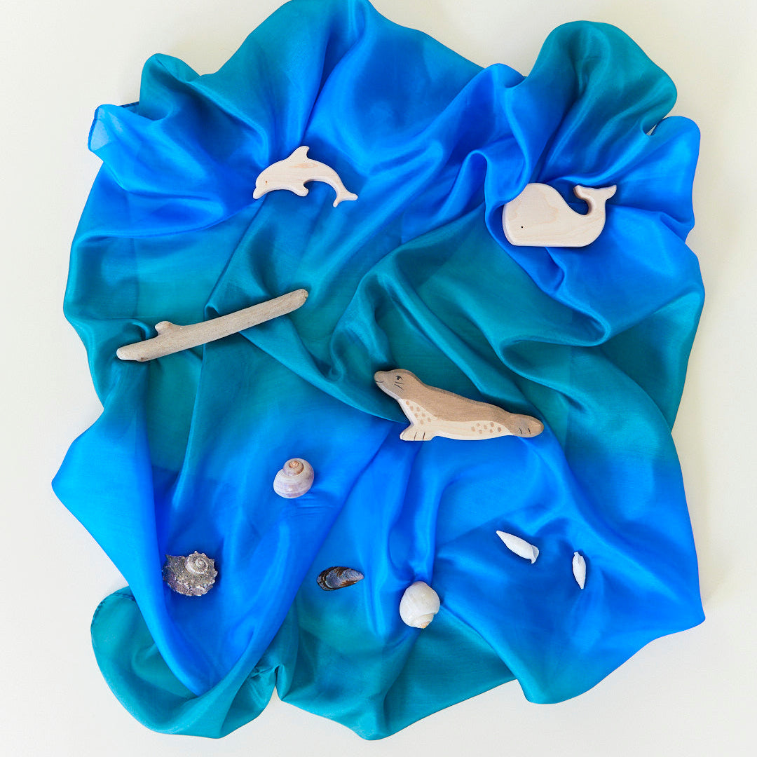 Blue fabric with marine animal cutouts on a white background