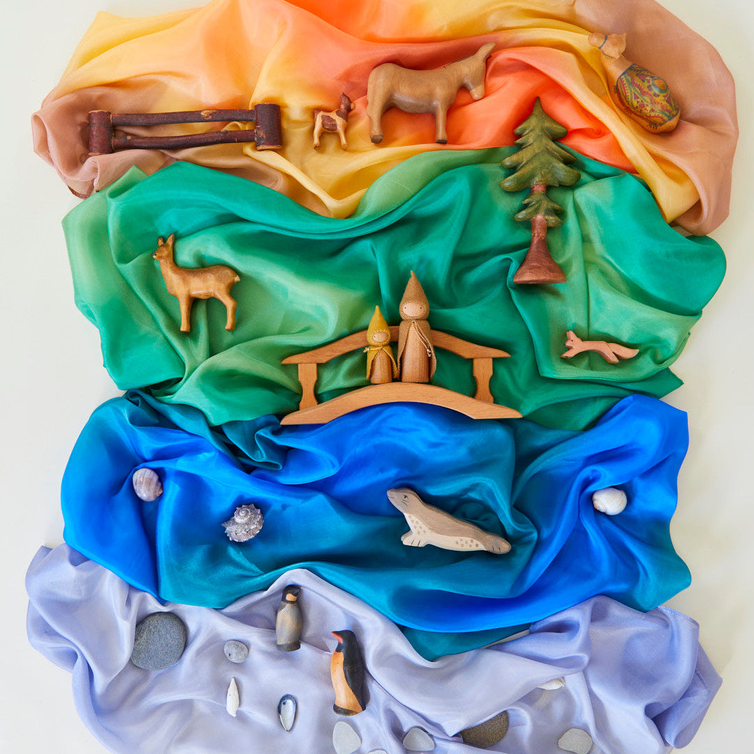 Colourful layered fabric with animal and nature-themed decorations on a white background
