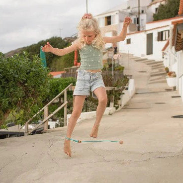 Young girl playing with a ankle swing on a residential street.