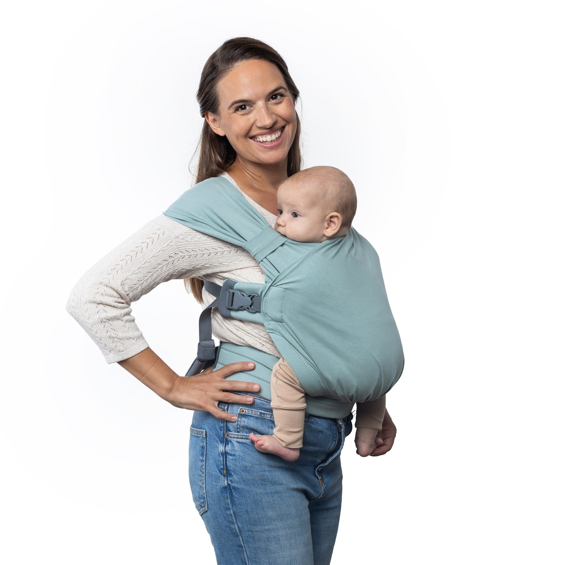 Woman holding a baby in a blue baby carrier against a white background
