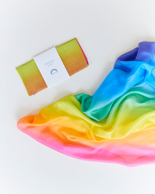 Rainbow-colored fabric with Sarah's Silks label on a white background