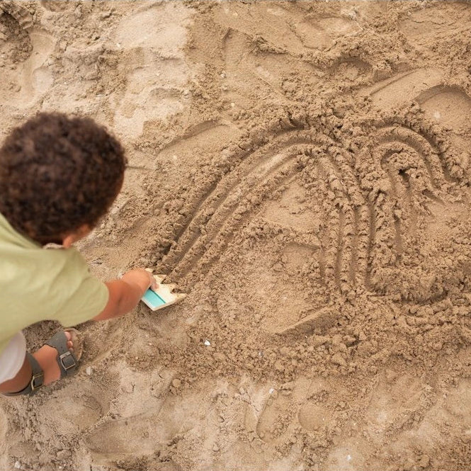 Person excavating a horse figure in sand