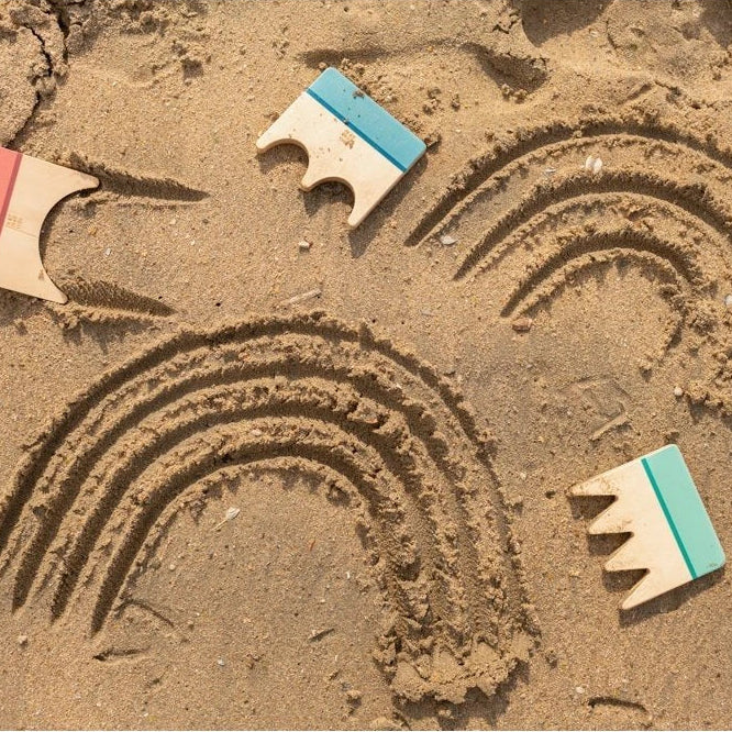 Sand art with rainbows on a sandy surface