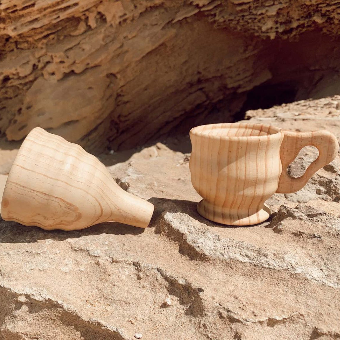 Wooden funnel and cup on a rocky surface with a natural stone background