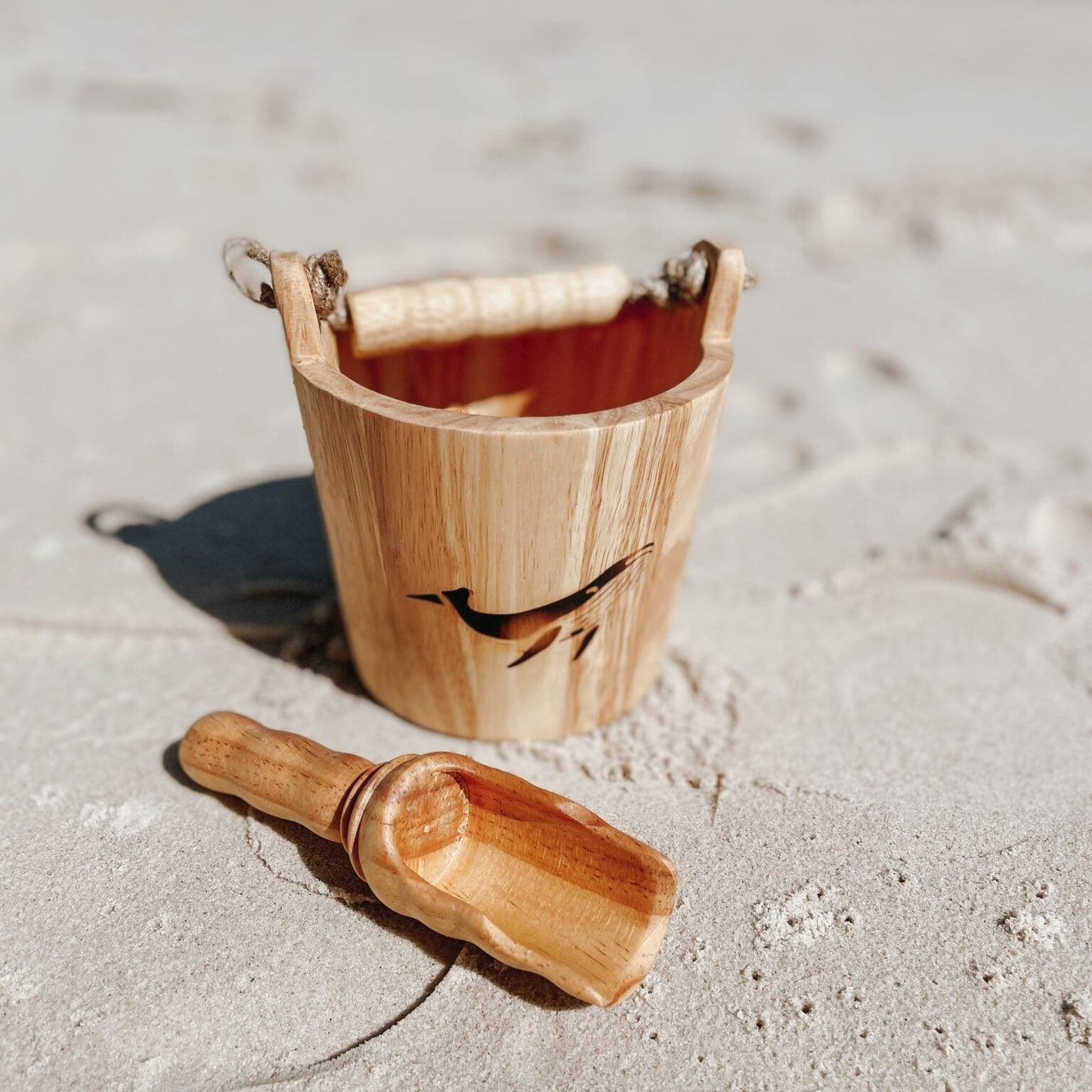 Wooden bucket and scoop on a sandy beach