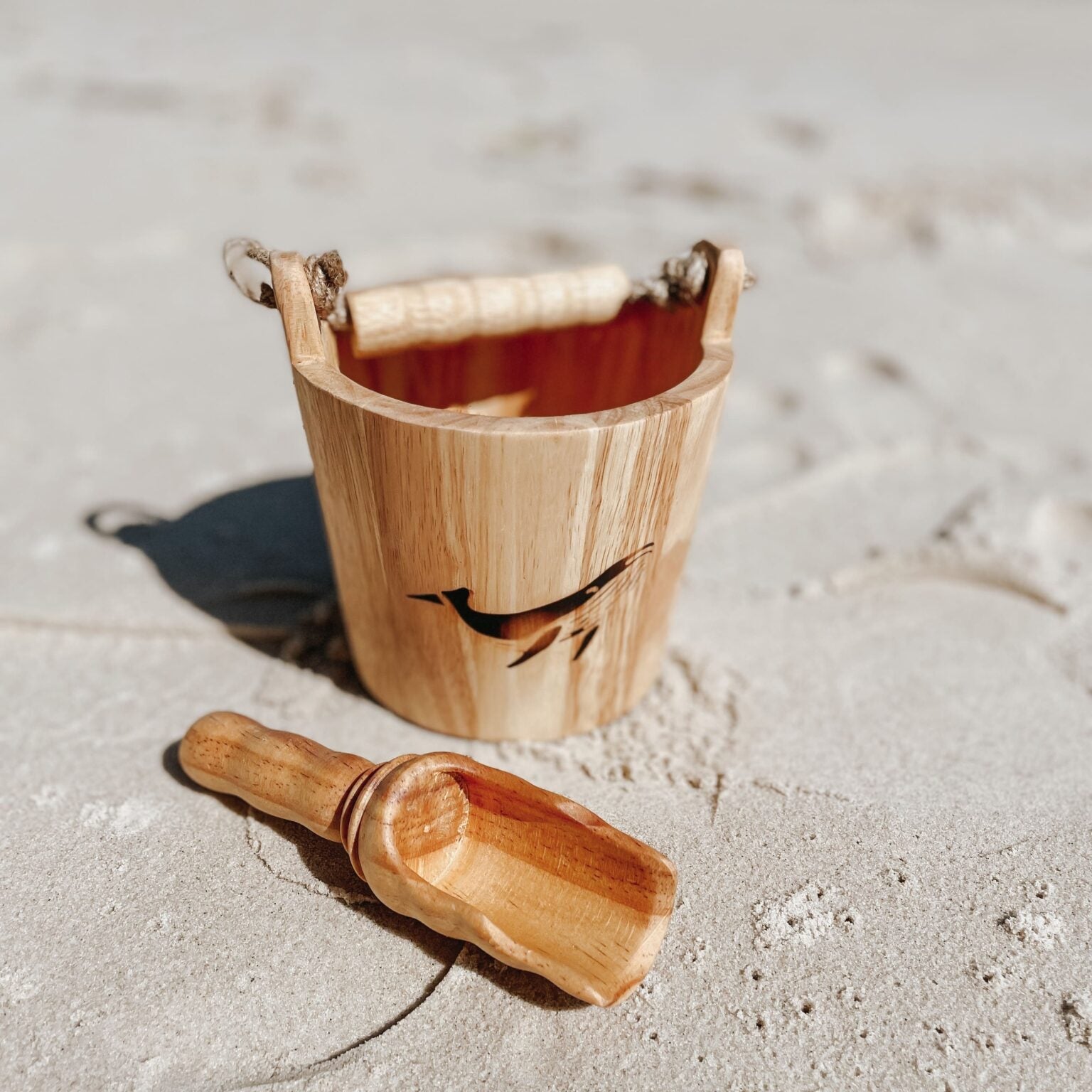 Wooden bucket and scoop on a sandy beach